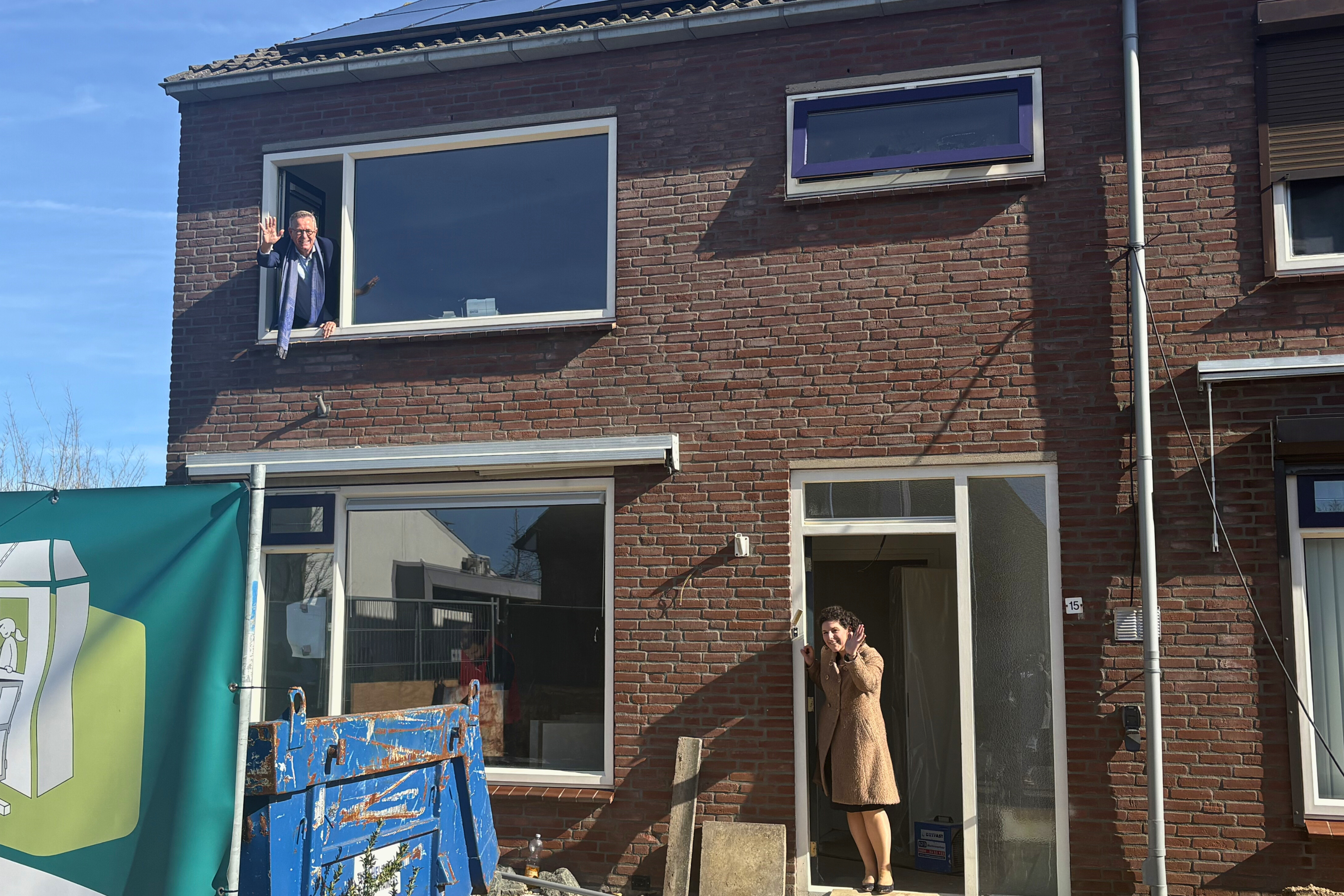 Marinus Kempe (Directeur-bestuurder Woonstichting De Kernen) en Wethouder Marieke van den Boom (gemeente West Maas en Waal) staan samen op de foto voor de woning die wordt gesplitst.